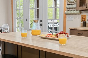 Eine Küchenarbeitsplatte mit einem Frühstücksbuffet, darunter Obst, Käse und Orangensaft.