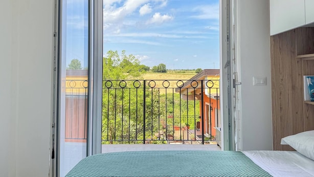Et værelse med en seng, et vindue med udsigt til en balkon, og en dør.