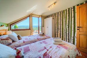 A bedroom with two beds, a large window, a wardrobe, and a view of the outdoors. - Trakoscan Castle View Pool House /w Private Spa (Bednja)