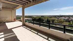 A balcony with a view of a town and a river.