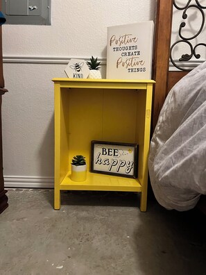A yellow bedside table with a small potted plant and a framed sign that says "BEE happy". - 3-bedroom house in marvelous Calera with WiFi, AC (Calera)