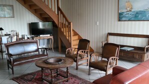 A living room with a wooden staircase, a television, a sofa, and a coffee table.