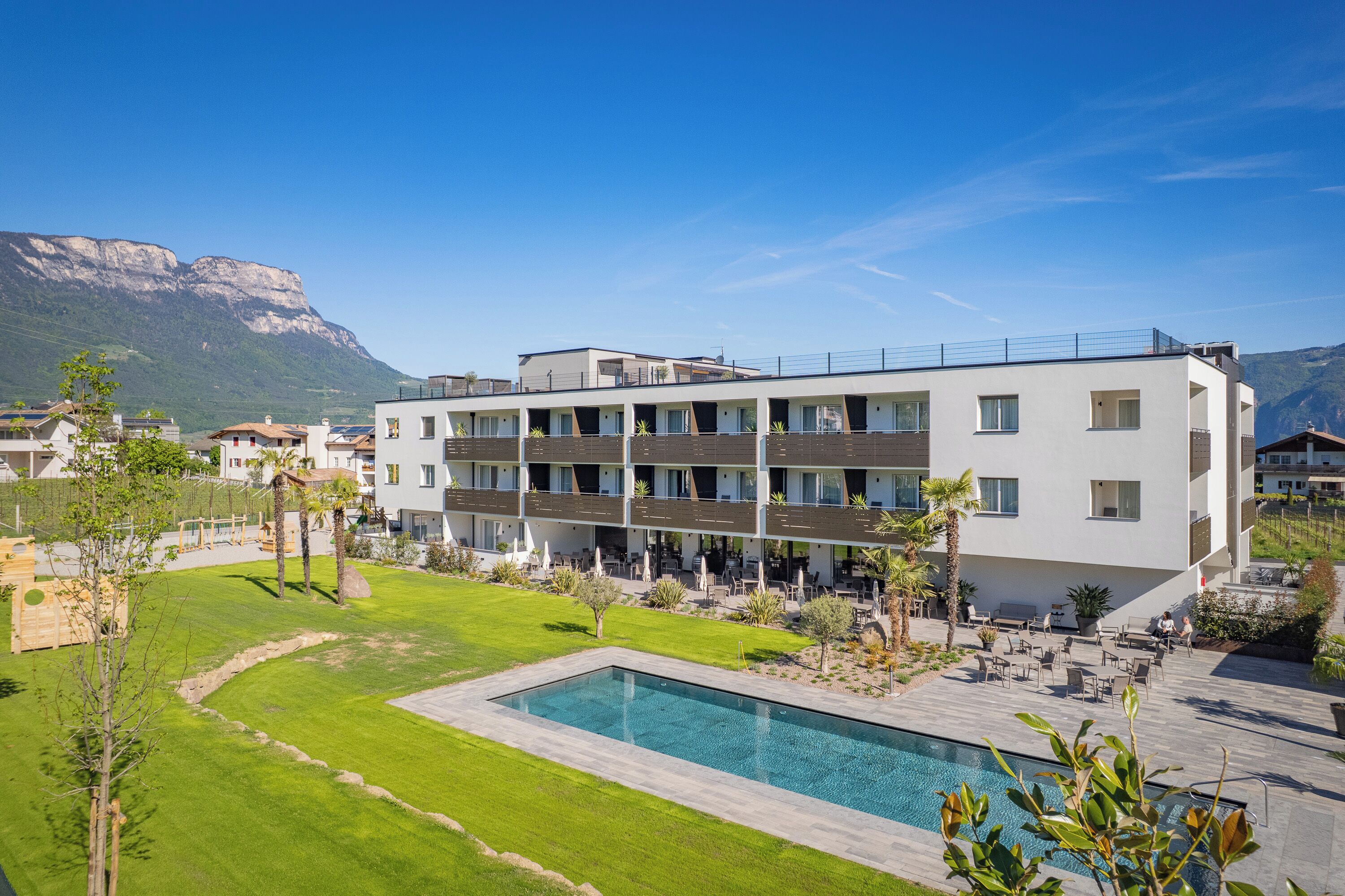 Un hôtel moderne doté d’une piscine, d’un espace extérieur aménagé et offrant une vue sur les montagnes.