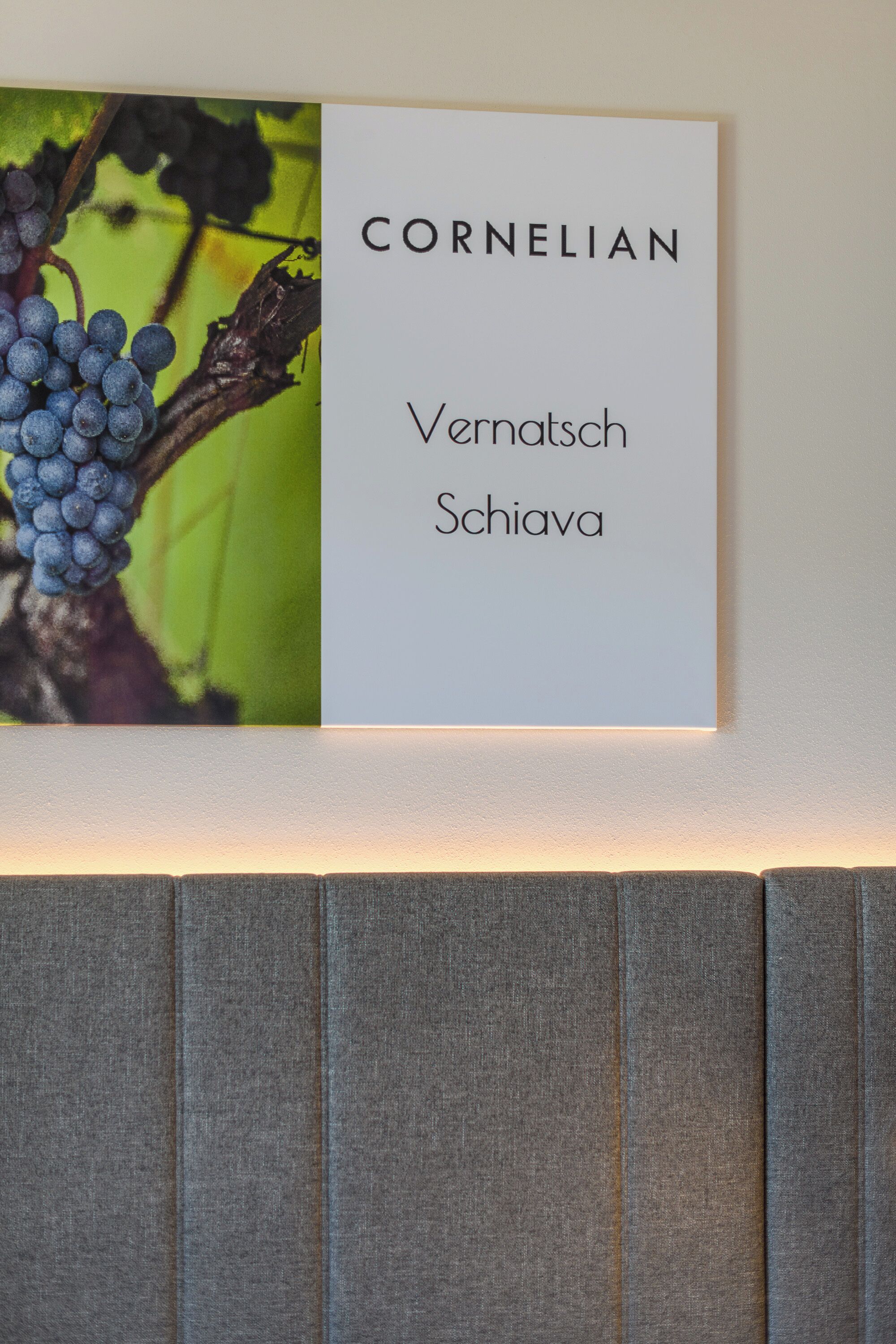 A framed sign with the text 'CORNELIAN Vernatsch Schiava' against a green background.
