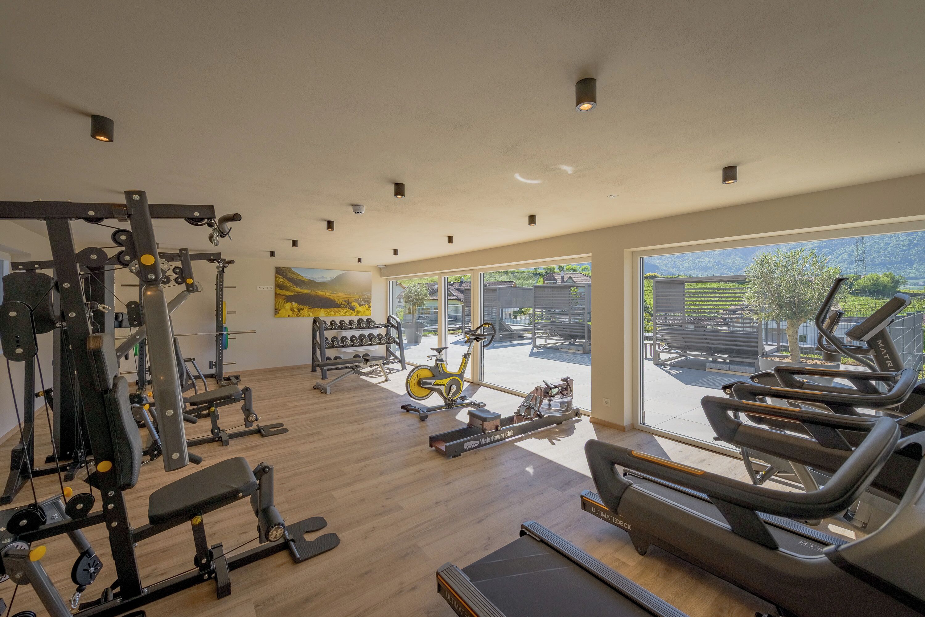 Une salle de sport équipée de matériel d’exercice, d’un rameur et d’un tapis de course.