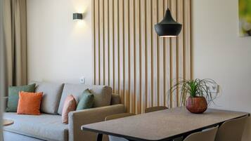 Un salon moderne avec un canapé, une table à manger et une plante en pot.