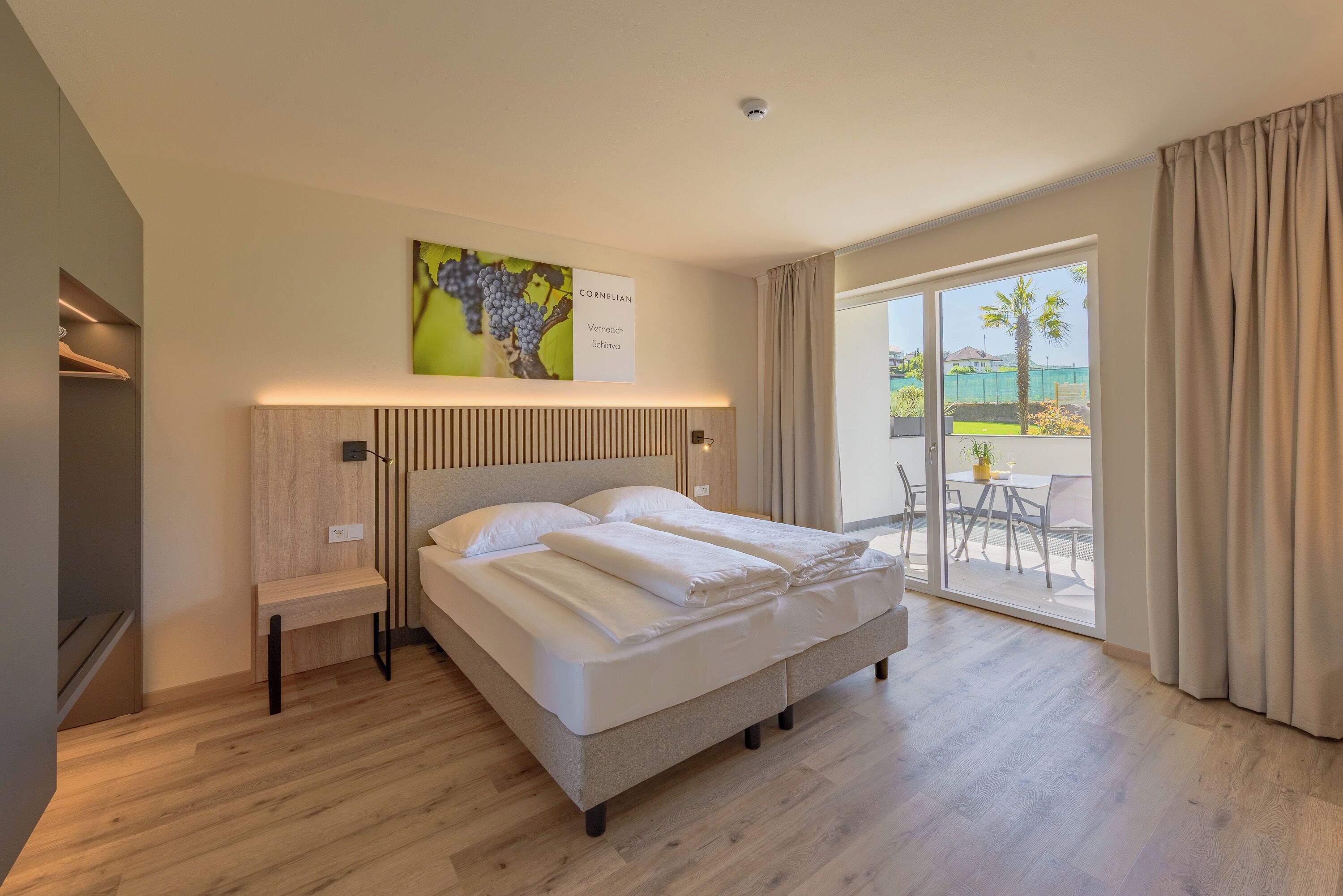 Une chambre d’hôtel moderne, dotée d’un grand lit, d’une table de chevet, d’une œuvre d’art accrochée au mur et offrant une vue sur l’extérieur.