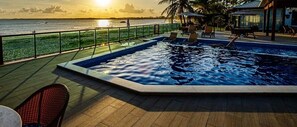 A swimming pool with a view of the sea and a sunset. - Beira Mar C Piscina e Area Gourmet 113D (Ipojuca)