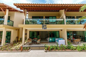 Um hotel com placa 'Stay Hall', área de estar ao ar livre e um pátio coberto.