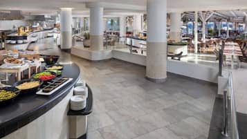 Zona àmplia de buffet amb diverses estacions de menjar i diferents disposicions de seients.