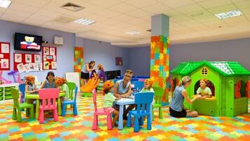 Una sala de jocs amb mobles de colors i una caseta.