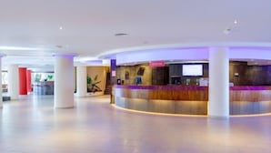 A spacious lobby with a reception desk, large pillars, and a modern design. - Sol Lanzarote All Inclusive (Puerto del Carmen)