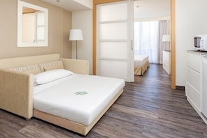 A hotel room with a bed, bedside lamp, a TV, and a view into the hallway. - Sol Lanzarote All Inclusive (Puerto del Carmen)