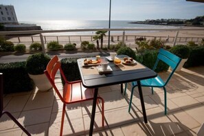 Una mesa con alimentos para el desayuno y vista al mar.