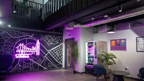 A modern interior with a neon London map, a vending machine, and seating area. - Student Only, Elegant Bronze Studio in Paddington (London)