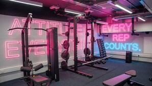 A gym with weightlifting equipment, benches, and a neon sign on the wall. - Student Only, Elegant Bronze Studio in Paddington (London)