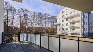 A balcony with a view of a modern building and leafless trees. - Rezydencja Willora Świnoujście (Swinoujscie)