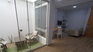 A room with a dining area, a sofa, a TV, and a wooden floor. - Apartment 5 minutes from downtown (Paracas)