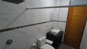 Een douche, handdoeken, zeep, toiletpapier