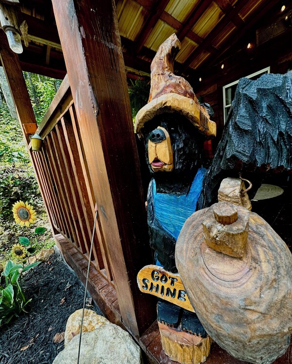 A wooden sculpture of a bear wearing a hat and a sign that says 'Got Shine.'
