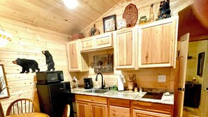 Un intérieur en bois comprenant un coin cuisine, une table à manger, des chaises et un tapis.