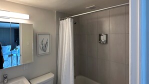 A bathroom with a toilet, sink, and shower.