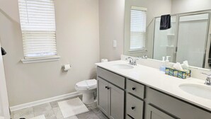 Un baño moderno con un tocador espacioso, un inodoro y una zona de ducha.