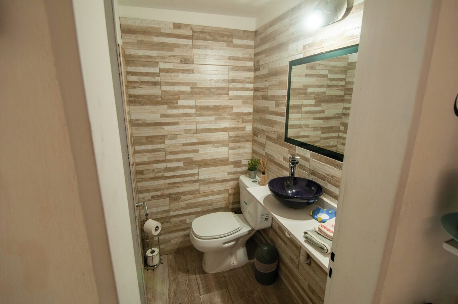 Une petite salle de bain avec des toilettes, un lavabo et un miroir.