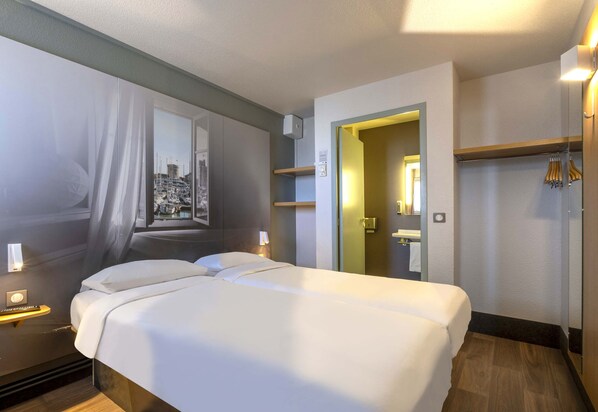 A hotel room with a large bed, a mirror, a wardrobe, and a view of a marina. - B&B Hotel La Rochelle Angoulins sur mer (Angoulins)