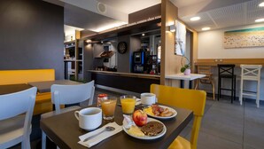 Uma mesa de café da manhã com máquina de café, frutas e ovos em um café moderno.