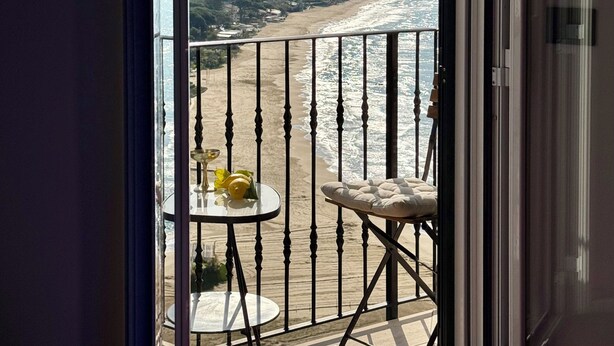 A balcony with a view of a beach and hills. - Casa Vacanza Eos (Sperlonga)
