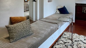 A modern living room with a sofa, a rug, and a pendant light. - Casa Vacanza Eos (Sperlonga)