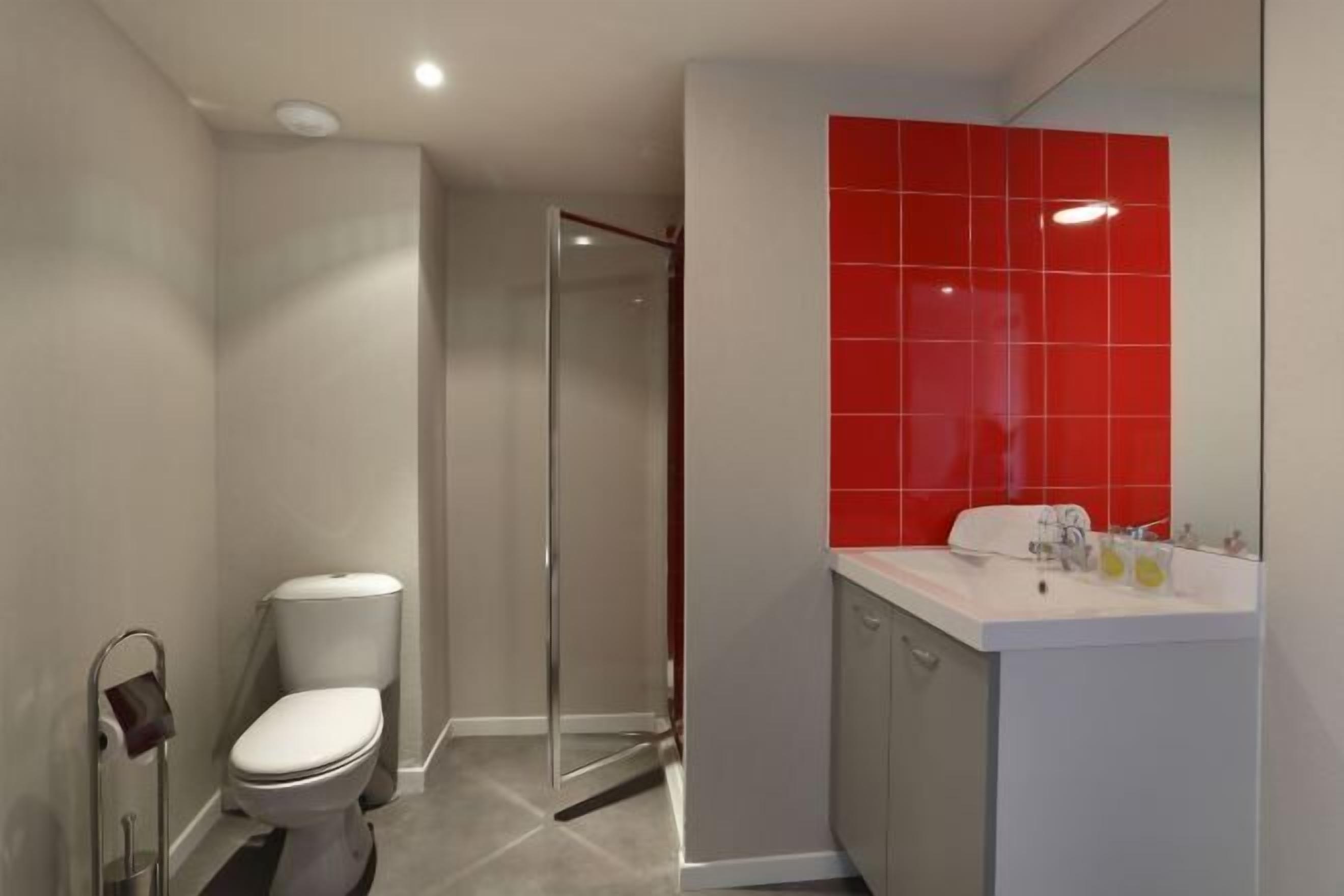 Un baño moderno con inodoro, ducha y lavamanos.
