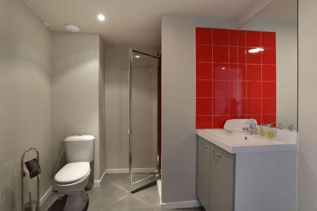 Un baño moderno con inodoro, ducha y lavamanos.