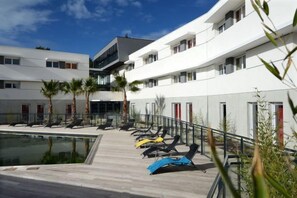 A hotel with a pool area, multiple balconies, and a modern architectural design. - Residence le Terral - Vacancéole (Saint-Jean-de-Vedas)