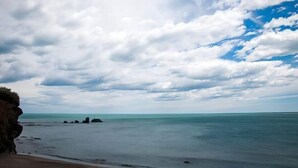 A beach with a rocky cliff and calm sea under a partly cloudy sky. - Residence le Terral - Vacancéole (Saint-Jean-de-Vedas)