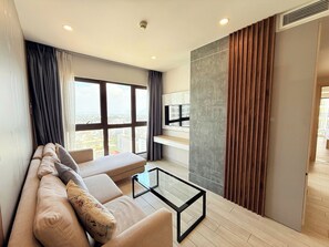 Familienapartment, Mehrere Betten, Strandblick, am Strand | Wohnbereich | 65-Zoll-Smart-TV mit Kabelempfang