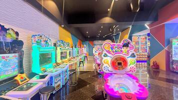 A row of arcade machines with colorful designs and a central game with a digital score display.