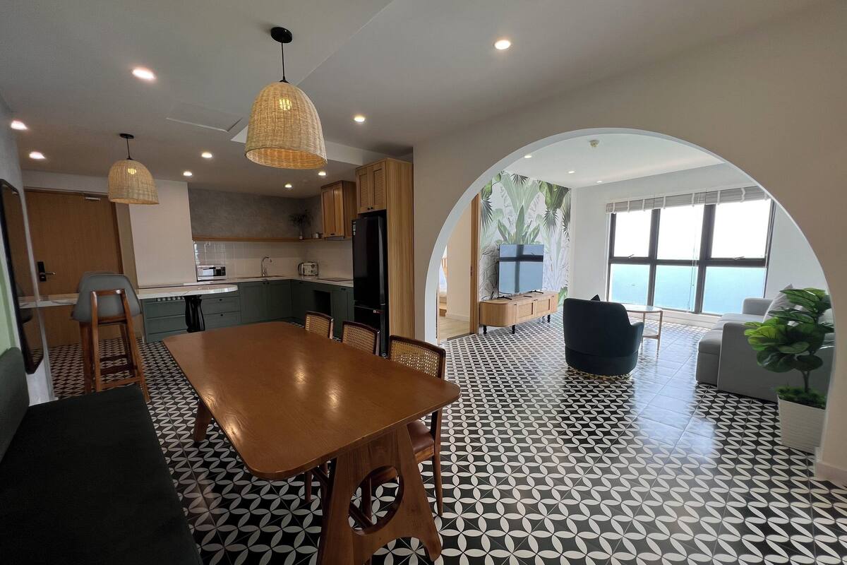 Una cocina moderna con comedor, un ventanal y vista al mar.