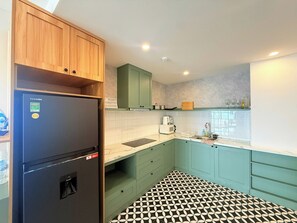 Una cocina equipada con refrigerador, microondas y armarios.