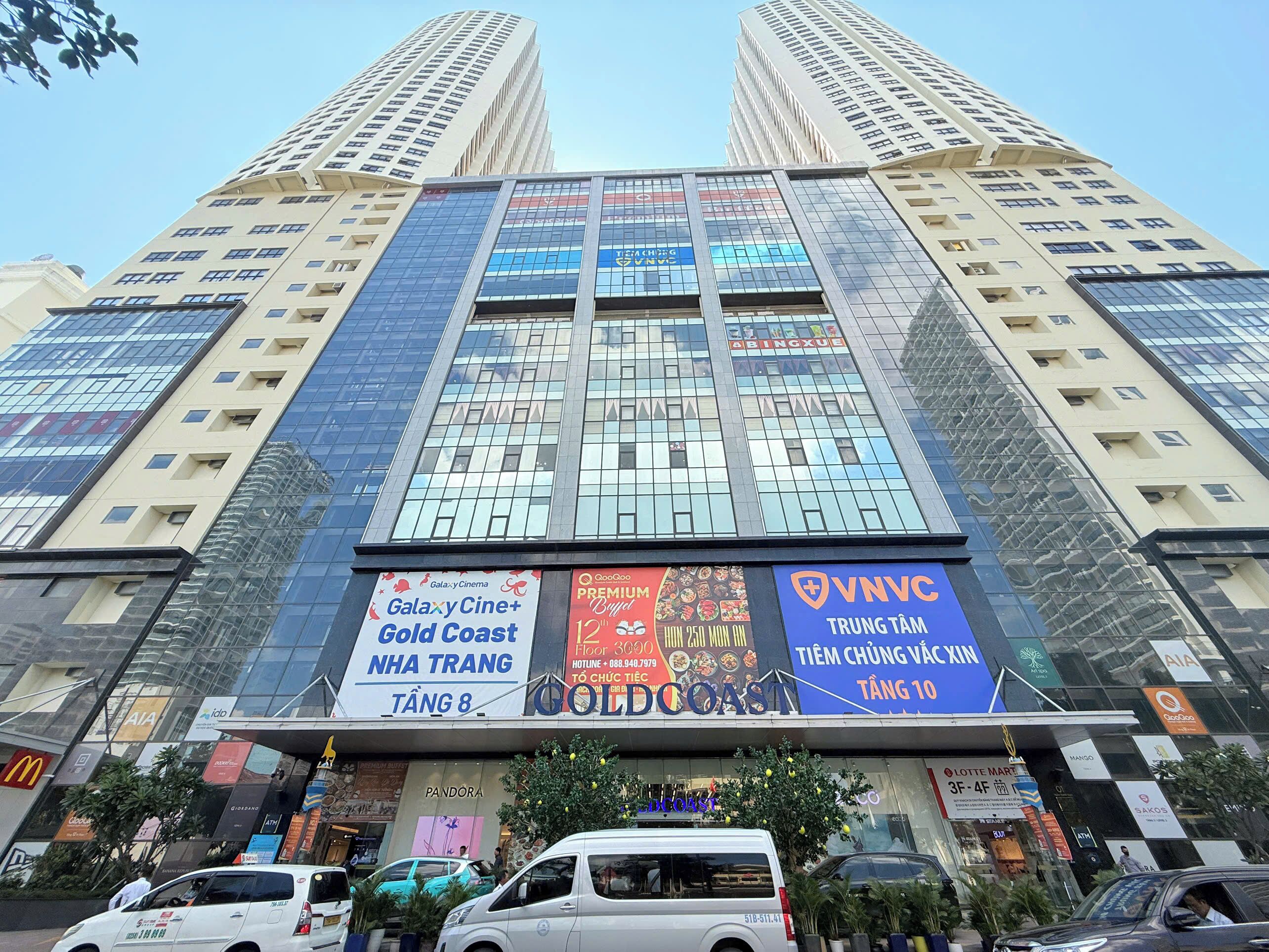 Un edificio de varios pisos con letreros comerciales, que incluyen un cine y un restaurante.