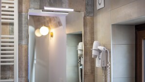 A bathroom with a mirror, a hairdryer, and a telephone. - L'Incanto delle Mura (Altamura)