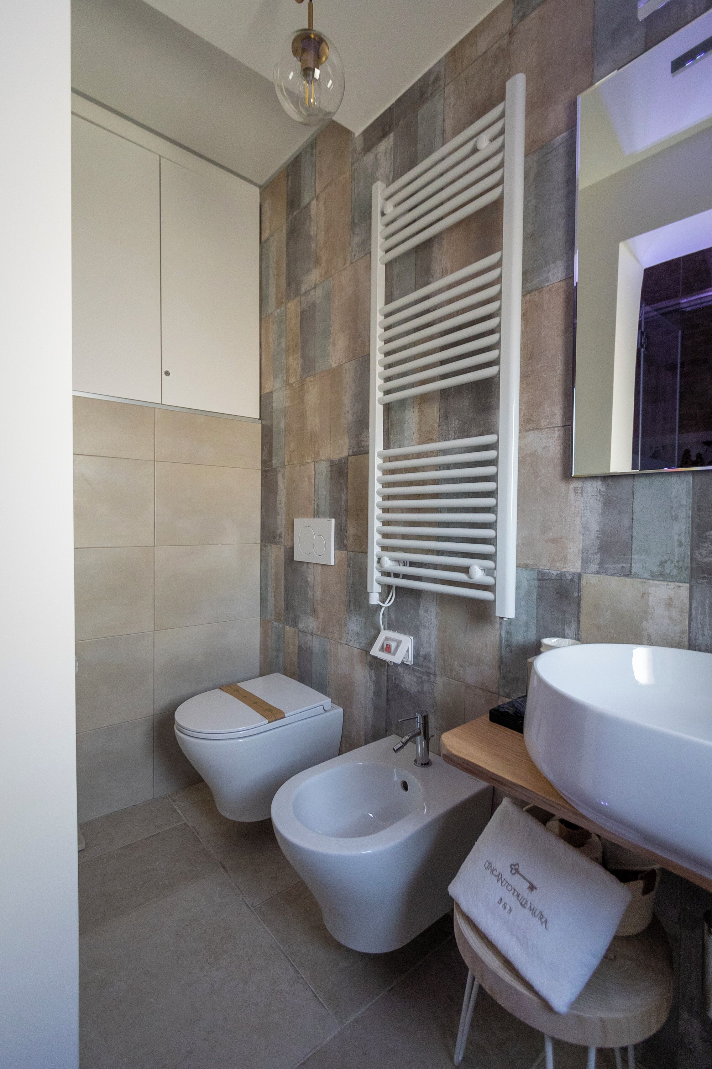 Un bany modern amb bidet, una rentatòria i una barra de tovalloles.