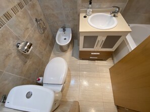 A modern bathroom with a toilet, bidet, sink, and cabinet. - 2º Line Apartment (Oropesa del Mar)