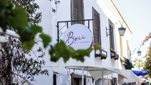 Un bâtiment blanc avec une enseigne indiquant « Bois, repos et petit-déjeuner ».