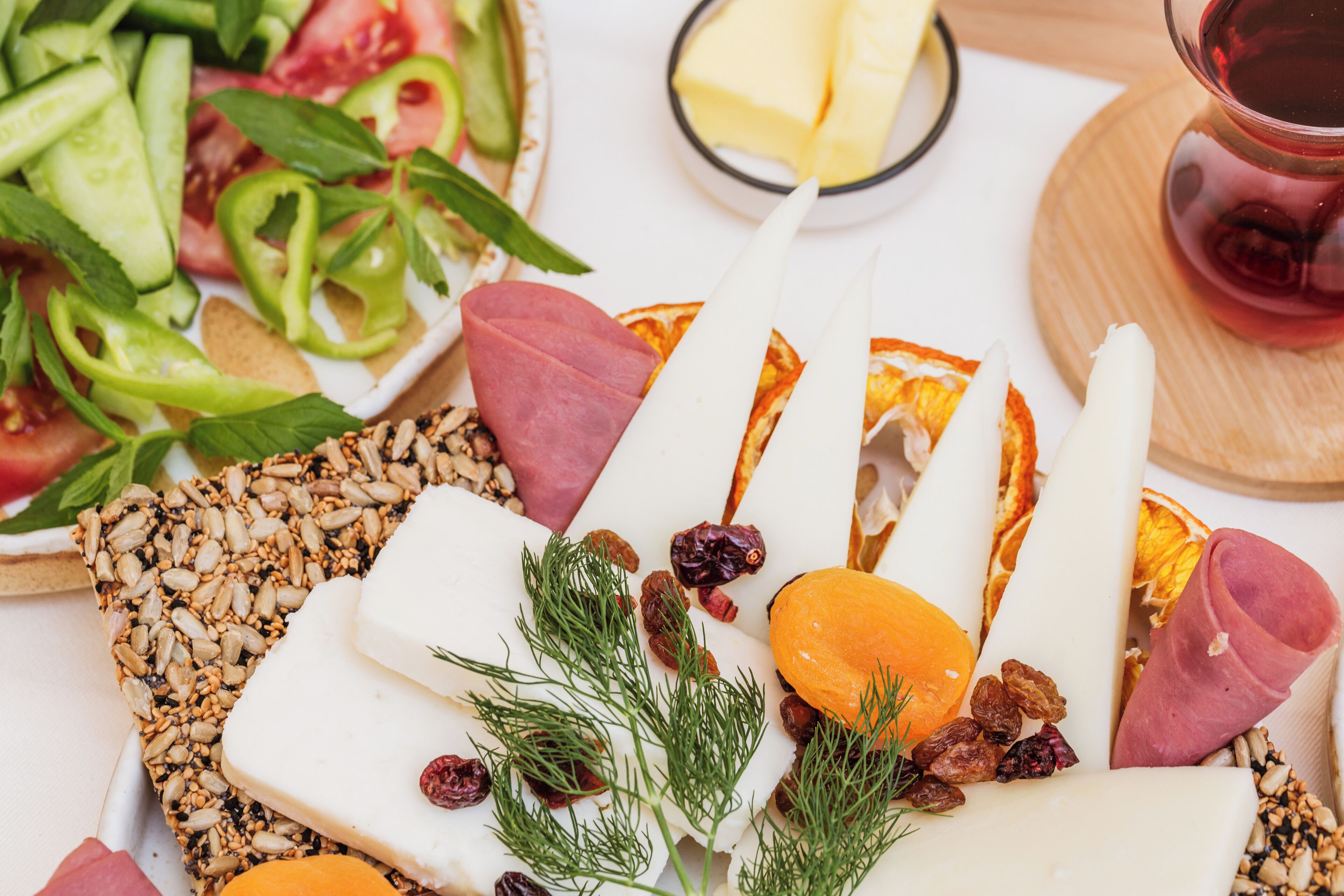 A charcuterie board with various cheeses, meats, nuts, and dried fruits.