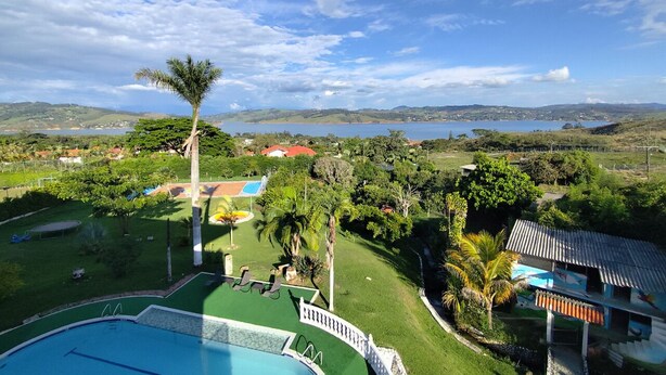Un área de piscina con vistas a un lago y colinas.