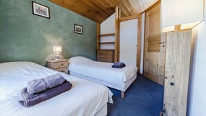 A room with two beds, a nightstand with a lamp, and a wooden wardrobe. - Pretty Savoyard chalet 100 metres from the slopes (Val-d'Isère)