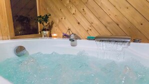 A bathtub with running water, a window, and a wooden wall. - Pretty Savoyard chalet 100 metres from the slopes (Val-d'Isère)