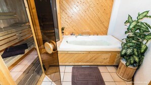 A wooden sauna with a bench, a glass-enclosed shower area, and a large bathtub. - Pretty Savoyard chalet 100 metres from the slopes (Val-d'Isère)
